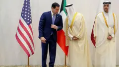 وزير الخارجية الأميركي ماركو روبيو مع وزير الخارجية الكويتي الشيخ جراح جابر الأحمد الصباح ووزير الخارجية القطري الشيخ محمد بن عبد الرحمن آل ثاني، يقفون أمام أعلام بلدانهم. 