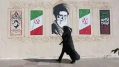 Obinrin ọmọ ilẹ Iran kan n rin kọja nibi ti aworan Oloogbe Ayatollah Ali Khamenei wa ni Tehran, Iran, ọjọ kẹẹẹdogun oṣu Keje, 2026.