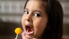 ਬੱਚੀ ਲਾਲੀ ਪੌਪ ਖਾਂਦੀ ਹੋਈ