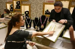 Bir kişi, 21 Mayıs 2026’da Hindistan’ın Cammu ve Keşmir bölgesindeki Srinagar’da düzenlenen bir mücevher fuarında altın kolye ve küpeleri inceliyor. 2025. 