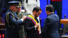 Abelardo de la Espriella yemin töreninde, iki asker ve bir sivil görevli tarafından giydiriliyor.