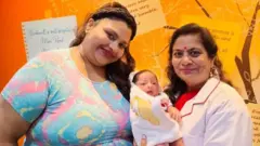 బిడ్డతో సిమోరా డీ. సౌజా, వైద్యురాలు