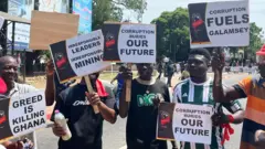 young protesters display placards demanding an end to illegal mining