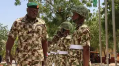 Nigeria's Chief of Defence Staff General Olufemi Oluyede (L) inspects the guard of honour at the Headquarters Theatre Command Joint Task Force in Maiduguri on March 18, 2026 during his visit after one of the deadliest attacks in the Borno state capital in years. 