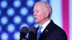 Joe Biden discursando, com bandeira dos EUAbet365 informaçõestelão ao fundo