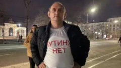 Vitaly Votanovsky vestindo uma camiseta com o slogan 'Não à guerra' escrito em russo