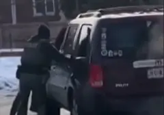 Dois policiais próximos de um carro