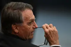 Bolsonaro no STF, olhando para o lado e segurando óculos