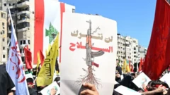 صور تظهر مُحتجين في لبنان يحملون لافتة ًكُتب عليها "لن نترك السلاح".