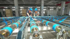 Operário em fábrica na cidade de Huzhou, província de Zhejiang, China, em 8 de setembro de 2025