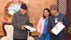प्रधानमन्त्री ओलीलाई प्रतिवेदन बुझाउँदै आयोगका संयोजक महेश थापा 