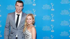 Na fotografia, Wladimir Klitschko, vestido com um terno cinza, aparece sorrindo com o braço em volta de Panettiere, que também sorri durante a recepção do Emmy Awards em 2013.
