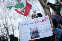 Mulher segura cartaz com foto de Pahlavi que diz: Obrigada Trump, vida longa a Pahlavi'