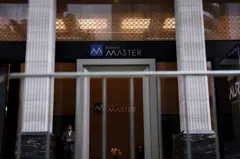 Um guarda de segurança parado à frente da entrada de sede do Banco Master em São Paulo