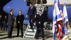 Марко Рубио спускается по трапу самолета в Израиле