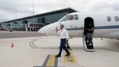 El expresidente Juan Orlando Hernández baja del vuelo privado en el que llegó a Honduras tras su indulto.