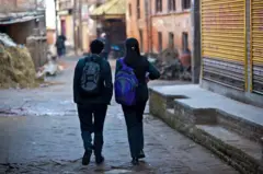 एउटा गल्लीमा हिँडिरहेका दुई जना विद्यार्थीहरूको तस्बिर। फाइल फोटो