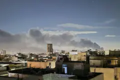 Una columna de humo asciende en un barrio de Irán