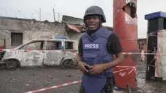 Umunyamakuru Paul Njie wa BBC imbere ya hamwe mu habereye imirwano i Goma