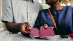 ፓስፖርት የያዙ እጆች