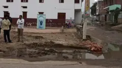 अंबेडकर नगर में दीवार के साथ खड़े कुछ लोग