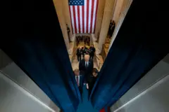 Foto tirada do alto mostra Trump e comitiva caminhandofezbet telegramdireção a porta, com bandeira dos EUA ao fundo