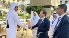 صورة تظهر أمير قطر تميم بين حمد آل ثاني يصافح الرئيس الإسرائيلي إسحاق هرتسوغ خلال لقاء عقد على هامش قمة للمناخ في دبي.