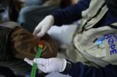 Un trabajador de Project HOPE midiendo el brazo de una persona.