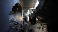 فلسطينيون يتفقدون موقع غارة إسرائيلية ليلية على منزل في مدينة غزة، 29 أكتوبر/تشرين الأول 2025