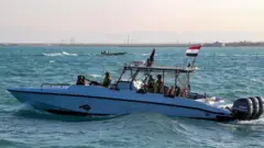 أفراد من خفر السواحل اليمنيين الموالين للحكومة المعترف بها دوليًا يركبون زورق دورية في البحر الأحمر قبالة مدينة المخا التي تسيطر عليها الحكومة في محافظة تعز الغربية، بالقرب من مضيق باب المندب الاستراتيجي، في 12 ديسمبر/كانون الأول 2023.