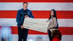 Elon Musk entregando cheque de US$ 1 milhão a Ekaterina Diestler
