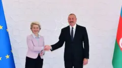 Президент Азербайджана Ильхам Алиев (справа) и председатель Европейской комиссии Урсула фон дер Ляйен (слева) пожимают друг другу руки после подписания меморандума о взаимопонимании по увеличению импорта азербайджанского природного газа в рамках встречи в Баку, Азербайджан, 18 июля 2022 года.