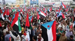 أشخاص يلوحون بأعلام جنوب اليمن والإمارات العربية المتحدة خلال تظاهرة في مدينة عدن الساحلية الجنوبية في اليمن، 30 ديسمبر/كانون الأول 2025
