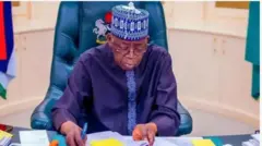Aarẹ Bola Tinubu n wo iwe kan, o mu gege ikọwe dani. Aarẹ wọ aṣọ alawọ aro, de fila to ni awọ kan naa, o si fi igo soju, o jokoo lori aga.