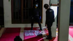 دو مامور پلیس مشغول بررسی مسجد محل حادثه هستند