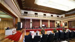 Uzun masalarda oturan kişiler