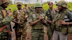 Abantu bahagaze mu mugwi, mu mwambaro wa gisirikare