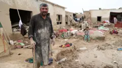 یک مرد در میان گل و لای ناشی از سیل 