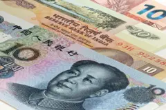 Notas de vários países, incluindo Índia e China, com uma nota de yuan chinês com o ex-líder Mao Zedong em primeiro plano.