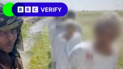 Un combattant regarde passer une file d'hommes capturés à al-Seriha.