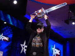 Elon Musk ergue uma motosserra ao descer do palco de conferência