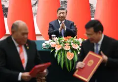 Xi Jinping aplaude enquanto um de seus ministros assina um acordo com um delegado europeu