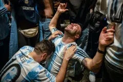 Hombre se abraza a otro durante la celebración por el triunfo de Argentina en el Mundial de 2022