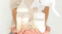 Žena drži flašicu sa mlekom i pumpu za mleko 