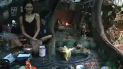 Nina na caverna, ao lado de raízes de árvore e vários objetos