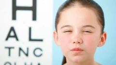 دختر بچه‌ای چشم‌هایش را تنگ کرده تا بهتر ببیند