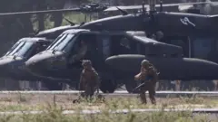 US Marines dressed in camouflage clothing and holding guns take part in training