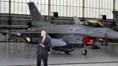Президент Польши Кароль Навроцкий на фоне истребителя во время посещения авиабазы