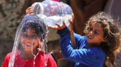 طفلة في غزة تصب الماء على رأس صديقتها التي تبتسم