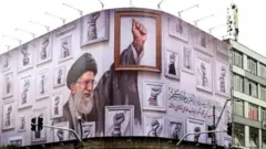 Waa sawir muujinaya hoggaamiyihii hore ee Iiran Ayyatullah Cali Khamenei oo lagu dilay weerarradii ugu horeyay ee dagalaka hadda socda.